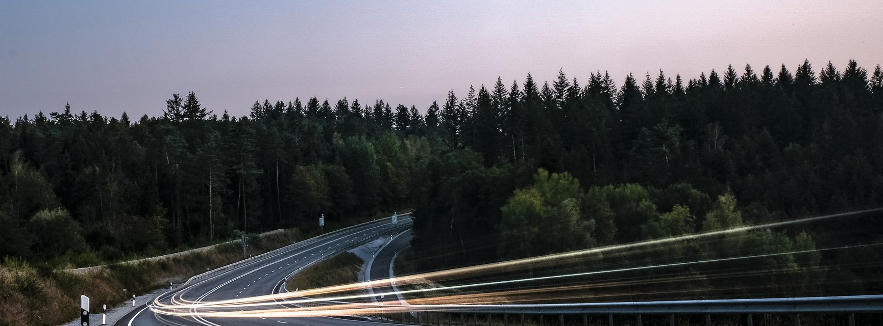 Symbolic image for mobility in rural areas. Car lights on a rural road.