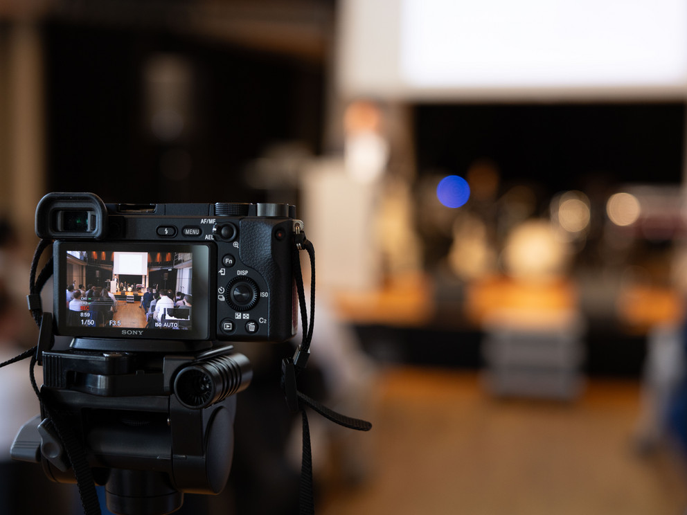 Camera capturing people on stage at the DPE Forum 2026