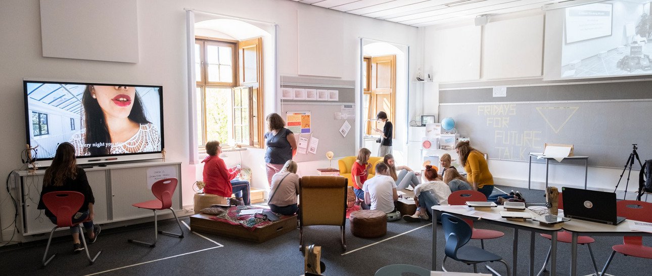 Links im Bild zu sehen ist eine Video-Installation zum Thema sexualisierte Gewalt gegen Frauen in Popul&auml;rkultur, rechts im Bild testen Besucherinnen und Besucher das analoge Escaping-Spiel.