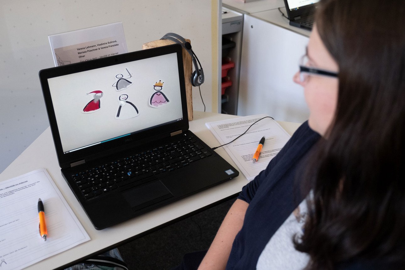 Eine Studentin schaut ein Video auf einem Laptop