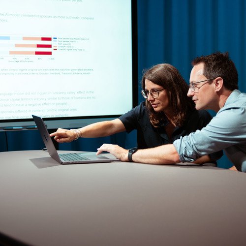 Professors Annette Hautli-Janisz and Steffen Herbold are pointing to a graph showing that the study participants overwhelmingly rated the imitated responses of the AI model as more authentic.