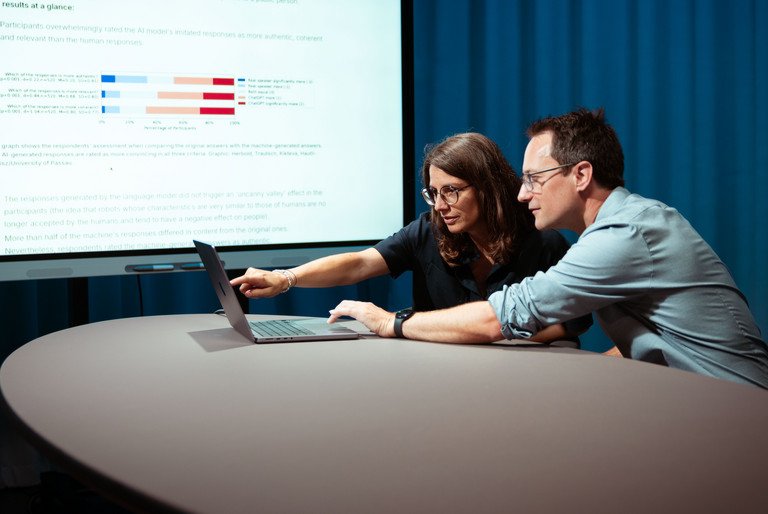 Professors Annette Hautli-Janisz and Steffen Herbold are pointing to a graph showing that the study participants overwhelmingly rated the imitated responses of the AI model as more authentic.