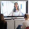 Aufnahme von zwei Frauen, die sich auf einer Leinwand die Video-Installation zum Thema sexualisierte Gewalt gegen Frauen in Populärkultur ansehen.