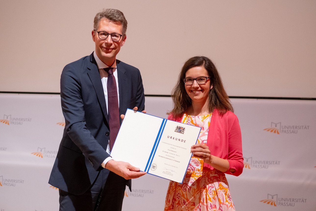 Auszeichnung f&uuml;r "herausragende Verdienste": Bayerns Wissenschaftsminister Markus Blume bei der &Uuml;bergabe der Urkunde an Prof. Dr. Hannah Schmid-Petri im Rahmen des Festakts zu "400 Jahre Akademische Tradition in Passau". Foto: Universit&auml;t Passau