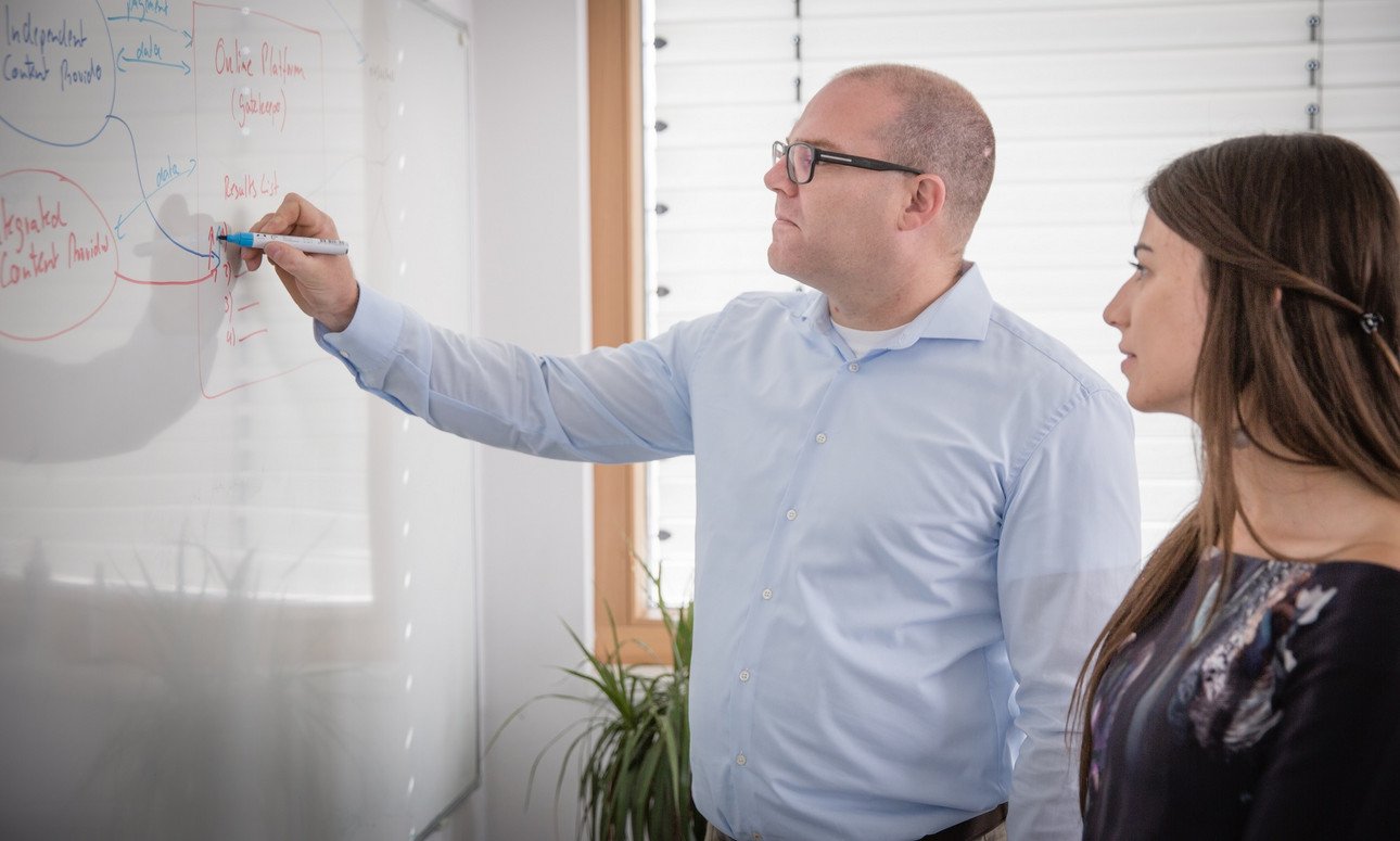 Prof. Dr. Kr&auml;mer und Doktorandin Janina Hofmann machen eine &Uuml;bersicht auf einem Whiteboard zum DFG-Projekt: Plattformneutralit&auml;t und datengetriebene Gesch&auml;ftsmodelle: Daten als Gegenleistung f&uuml;r eine prominente Platzierung von Anbietern auf Onlineplattformen&ldquo;
