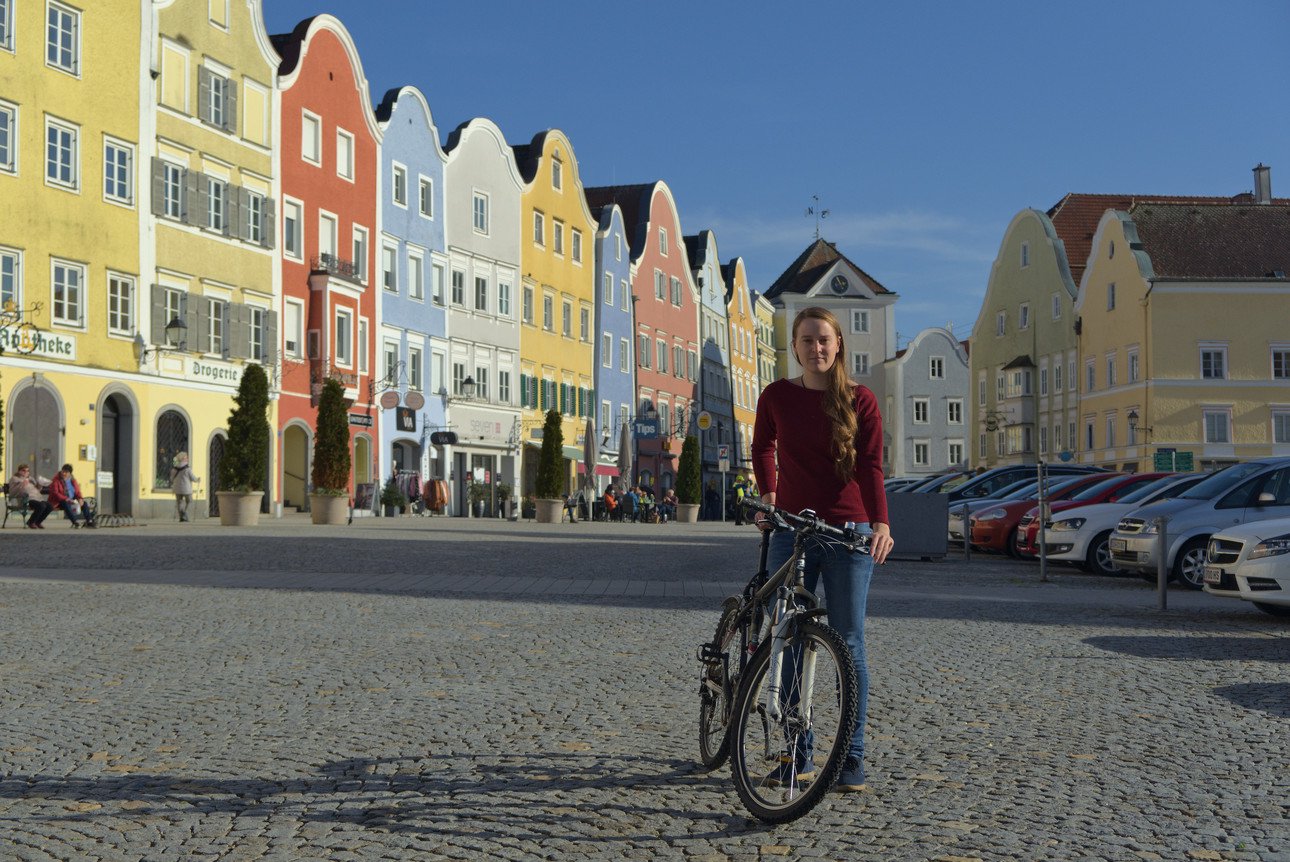 Janina K&ouml;rber, standing on the market sight of Sch&auml;rding in front of the local tourism spot "Silberzeile" with her bicicle. 