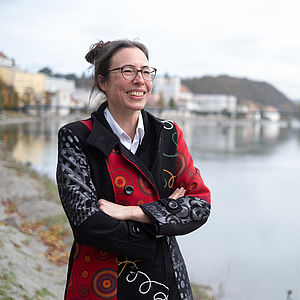 Prof. Dr. Christine Schmitt im Portrait vor dem Panorama des Inns und der Stadt Passau.