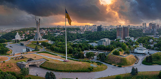 Panorama-Blick auf Kiew in düsterer Stimmung. Vorne im Bild zu sehen ist die Mutter-Heimat-Statue, eine Kolossalstatue, mit der die Sowjetunion den Sieg über Nazi-Deutschland feierte. Foto: Adobe Stock